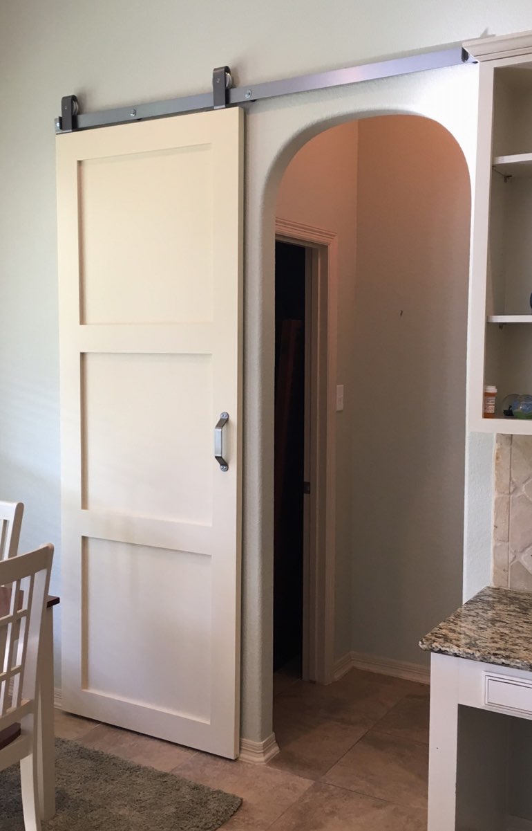 White shaker barn door used as bedroom door 